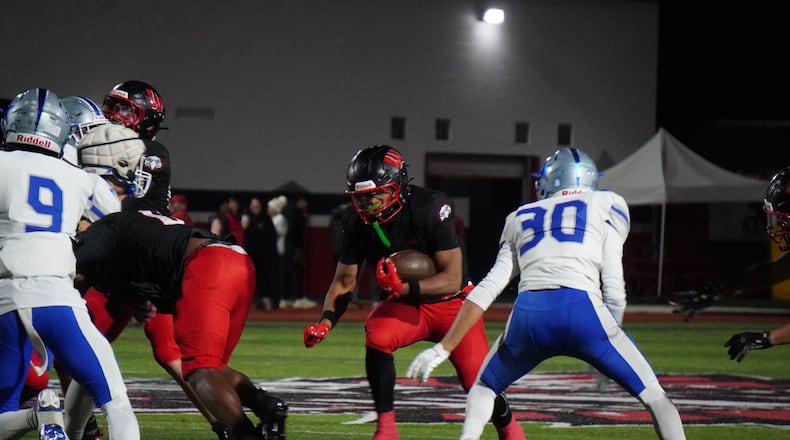Lakota West's Tyson Davis carries the ball as Hamilton's Chase Moak looks to make a tackle during their Division I, Region 4 playoff game on Friday night at Firebird Stadium. CHRIS VOGT / CONTRIBUTED