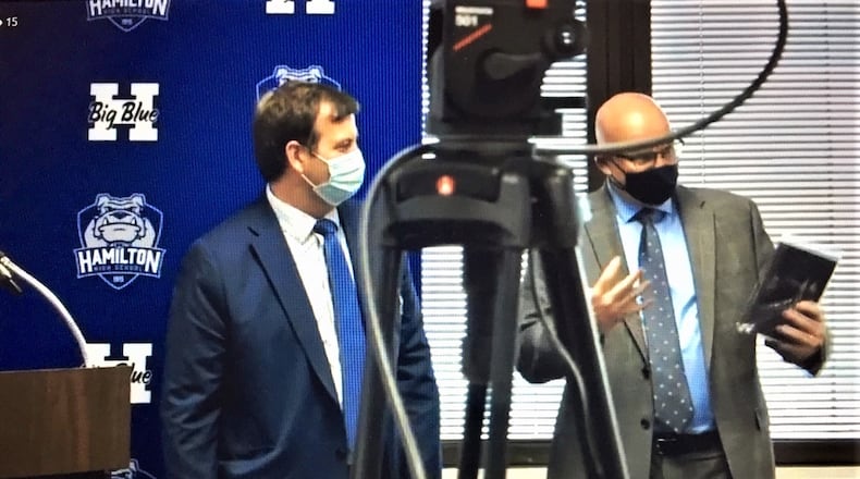 Hamilton Board of Education member Rob Weigel, left, announced his resignation Thursday evening and was presented a plaque of appreciation from Hamilton Schools Superintendent Mike Holbrook. Weigel, a former president and vice president on the board, said he wanted to spend more time with his family in explaining his departure from the governing board. (Photo by Michael D. Clark\Journal-News)