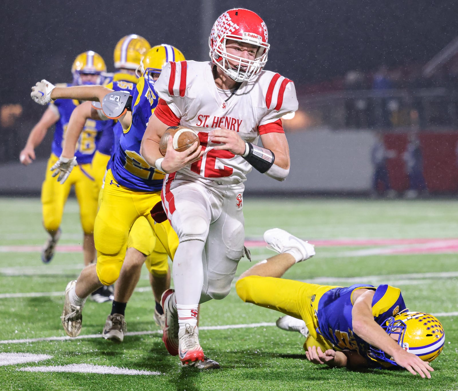 St. Henry senior quarterback Charlie Werling runs ahead of Marion Local defenders during a 45-yard touchdown run in the second quarter of the Division VII, Region 28 championship game on Friday, Nov. 21 at Mercy Health/Wapak VFW Field in Wapakoneta. Werling scored four TDs to help the Redskins win 24-7 and snap a 76-game winning streak by the Flyers. BRYANT BILLING/STAFF
