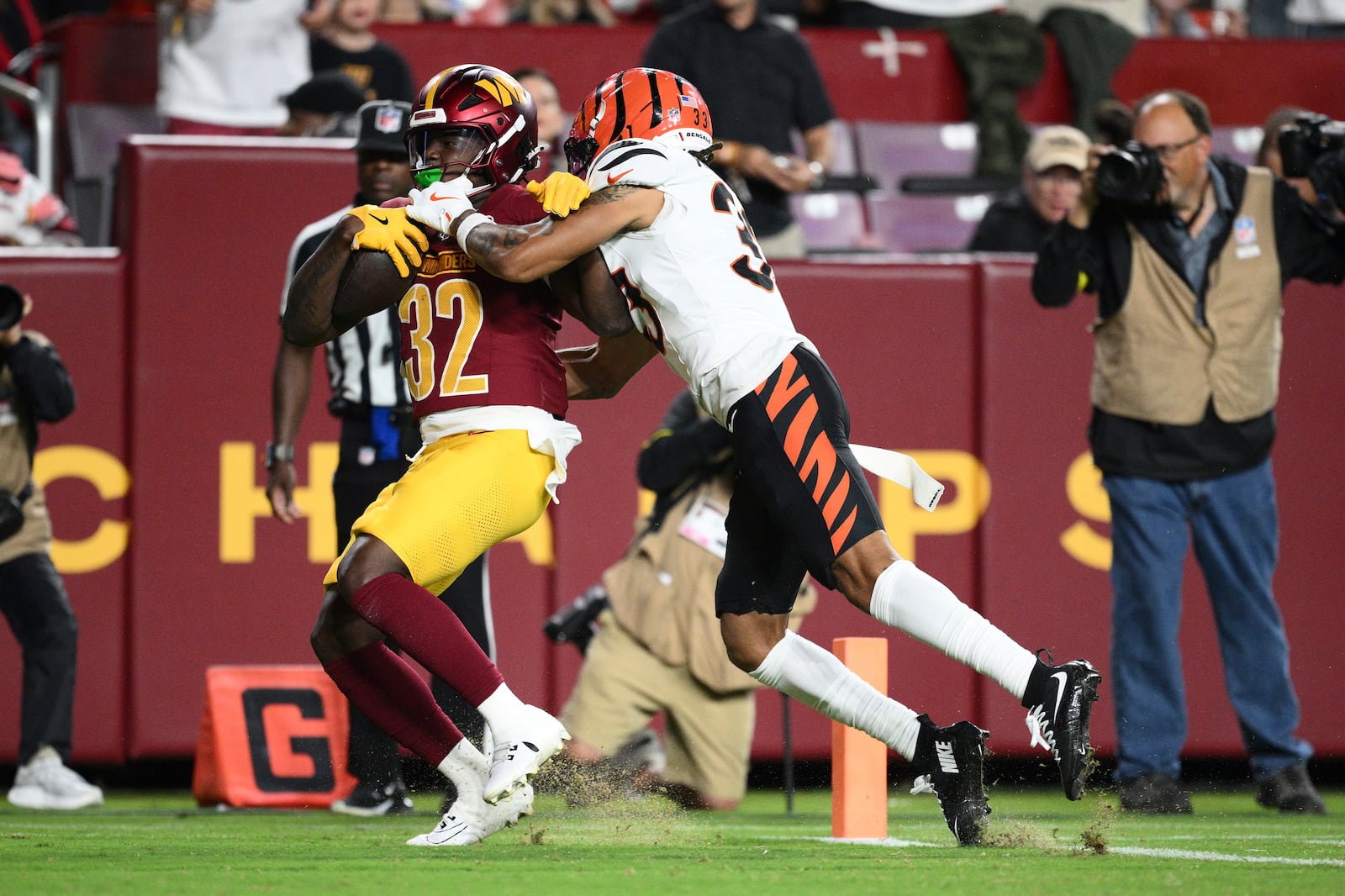 Washington Commanders running back Jacory Croskey-Merritt (32) scores past Cincinnati Bengals safety Daijahn Anthony during the first half of a preseason NFL football game Monday, Aug. 18, 2025, in Landover, Md. (AP Photo/Nick Wass)