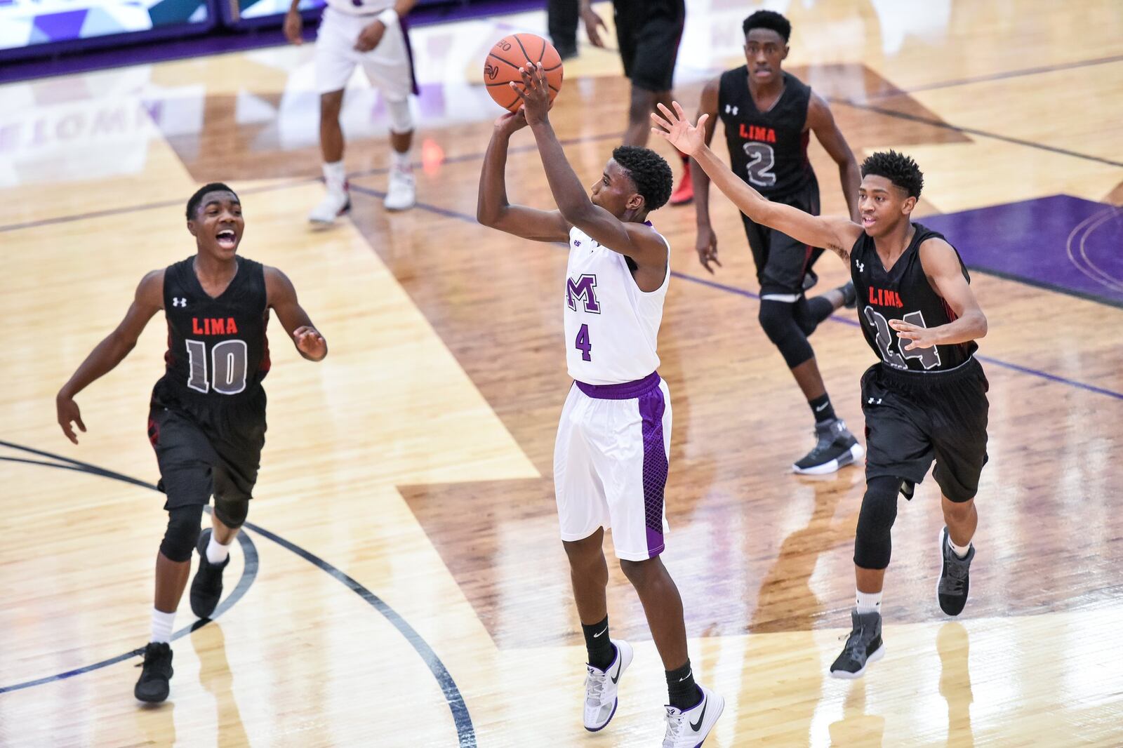 Middletown’s Aaron Jones puts up a shot while being surrounded by Lima Senior’s Amihr Curtis (10), Cory Clair (2) and Greg Johnson (24) on Saturday night at Wade E. Miller Arena in Middletown. NICK GRAHAM/STAFF