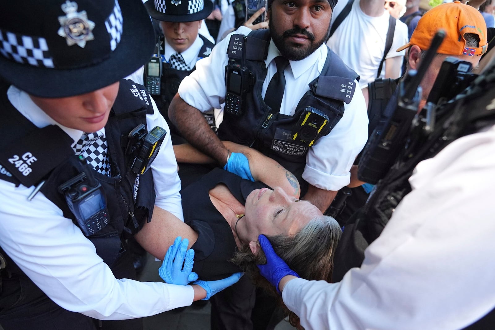 Police officers remove a person after they took part in a protest in Parliament Square, to call for de-proscription of 'Palestine Action' after a ban against the organisation was announced, in London, Saturday July 12, 2025. (James Manning/PA via AP)