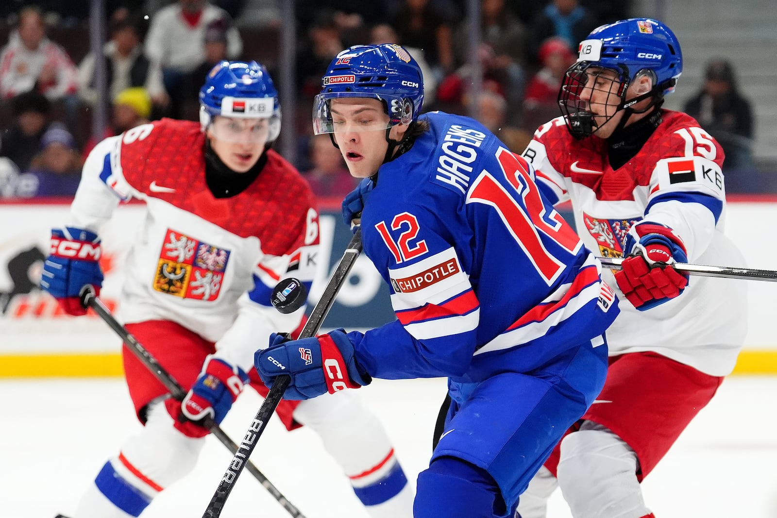 FILE - United States forward James Hagens (12) moves the puck while under pressure from Czechia forward Vojtech Cihar (15) during first-period World Junior hockey championship semifinal game action in Ottawa, Ontario, Jan. 4, 2025. (Sean Kilpatrick/The Canadian Press via AP, file)