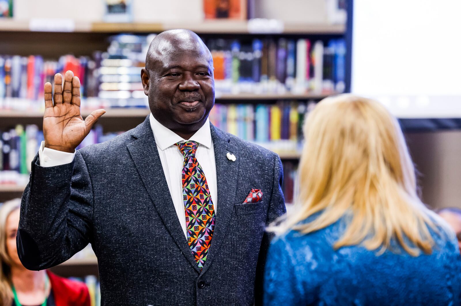 Isaac Adi, left, is sworn in early to Lakota School Board by school board member Lynda O'Connor before the meeting Thursday, Dec. 16, 2021 at Lakota Plains Junior School in Liberty Township. NICK GRAHAM / STAFF