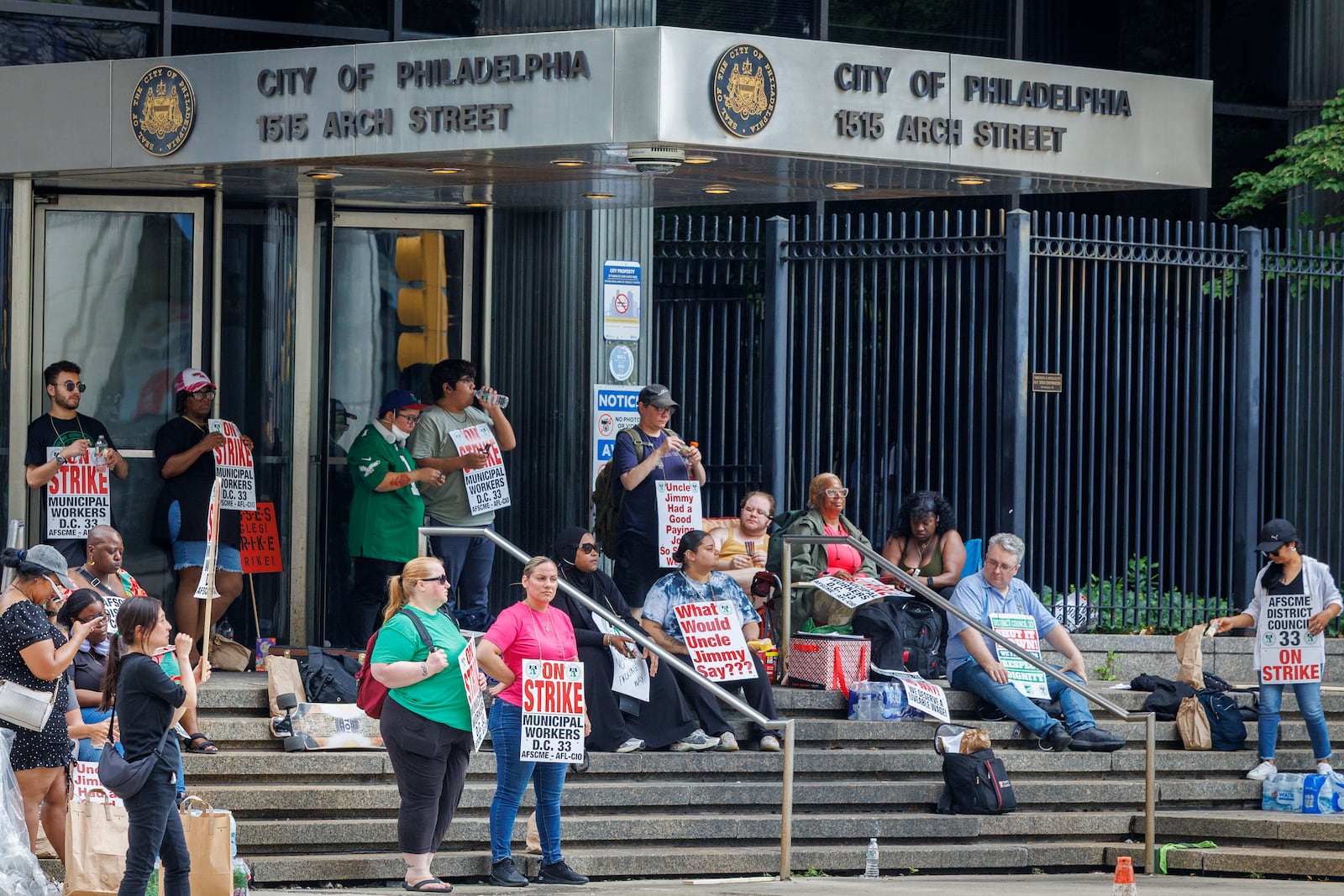 People hold signs on the first day of strike by the Philadelphia municipal workers, AFSCME District Council 33 outside municipal offices on Tuesday, July 1, 2025. (Alejandro A Alvarez/The Philadelphia Inquirer via AP)