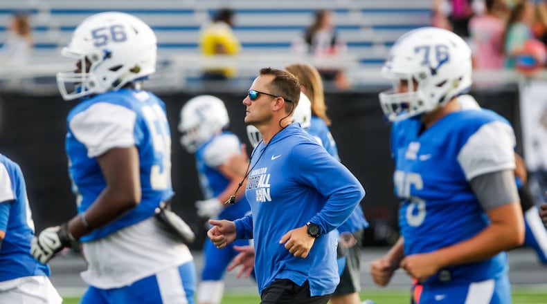 Hamilton head football coach Nate Mahon runs up the field with the team during warm-ups before their game against Anderson Friday, Sept. 6, 2019, at Virgil M. Schwarm Stadium in Hamilton. Big Blue won 28-14. NICK GRAHAM/STAFF