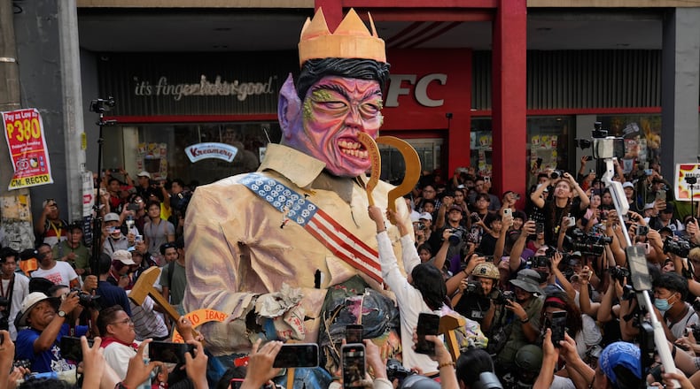 Protesters destroy an effigy of Philippine President Ferdinand Marcos Jr. during an anti-corruption rally in Manila, Philippines on, Sunday, Nov. 30, 2025. (AP Photo/Aaron Favila)