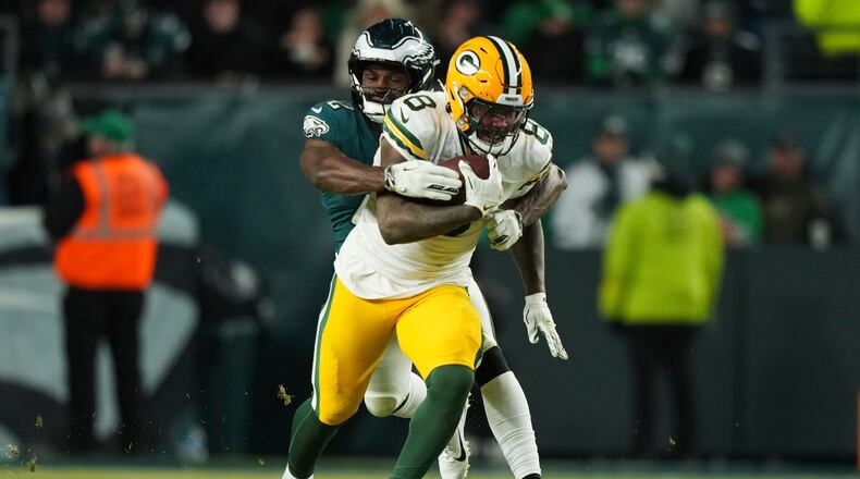 Green Bay Packers running back Josh Jacobs (8) is tackled by Philadelphia Eagles linebacker Oren Burks (42) during the second half of an NFL wild-card playoff football game Sunday, Jan. 12, 2025, in Philadelphia. (AP Photo/Matt Slocum)