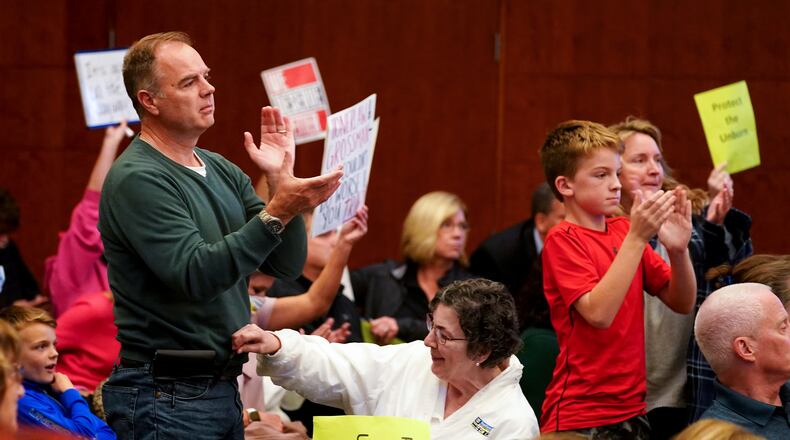 Attendees react as Mason city council passed an ordinance criminalizing abortions within the city limits, by a vote of four votes to three, Monday, Oct. 25, 2021, at the Mason City Building. It failed to pass as an emergency, meaning it won't go into effect for 30 days. (Kareem Elgazzar/The Cincinnati Enquirer via AP)