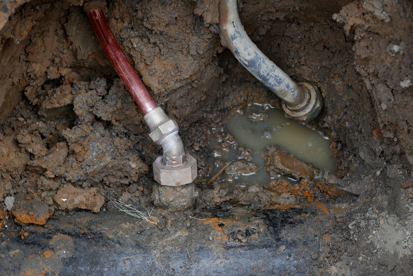 FILE - A copper water supply line, left, is shown connected to a water main after being installed for lead pipe, right, in Flint, Mich., Friday, July 20, 2018. (AP Photo/Paul Sancya, File)