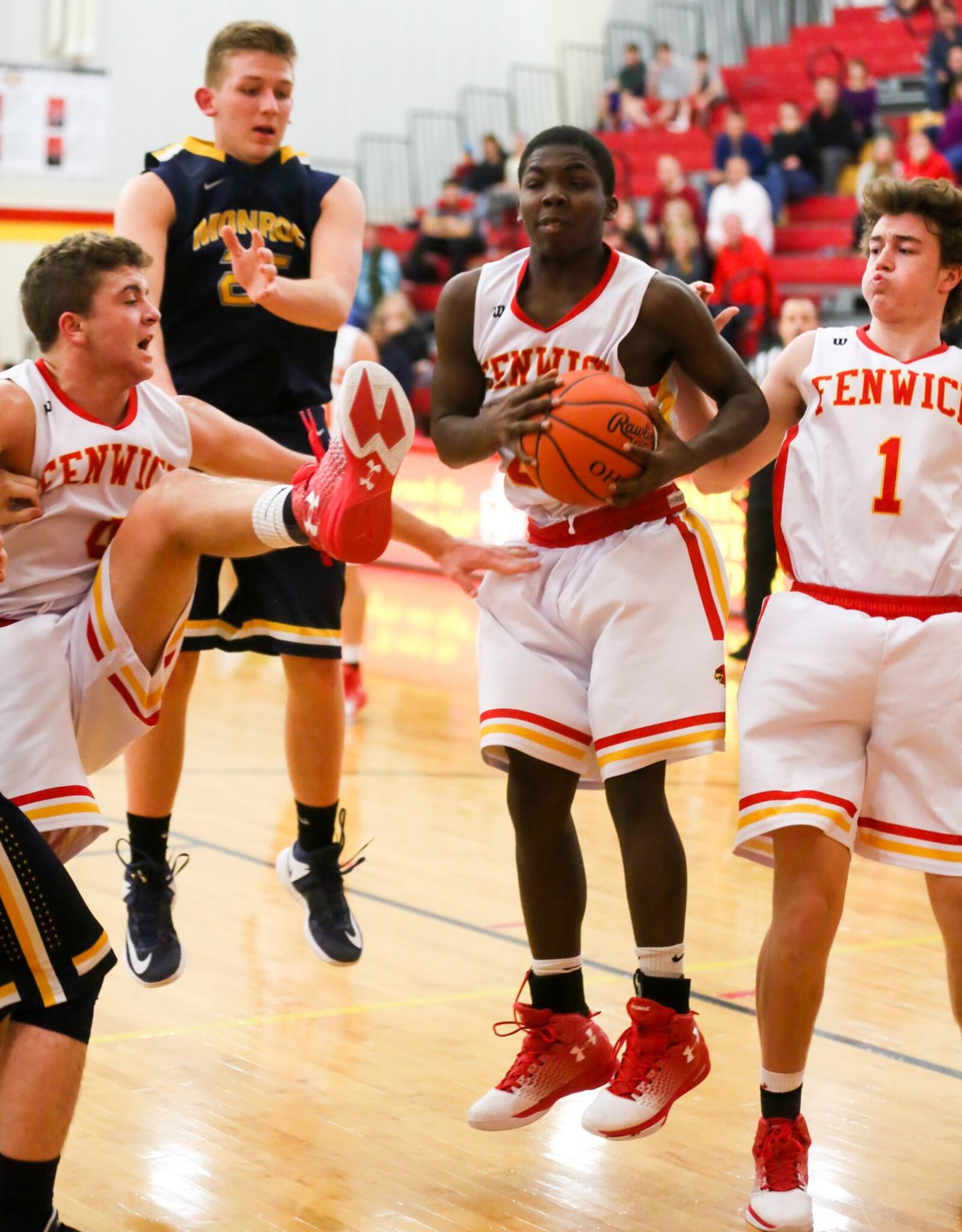Fenwick guard Caleb Davis (0) grabs a rebound between teammates Sammy DeBiasi (left) and Zachary Lorei (1) as Monroe’s Matt DeHart (25) watches Tuesday night at Fenwick. GREG LYNCH/STAFF