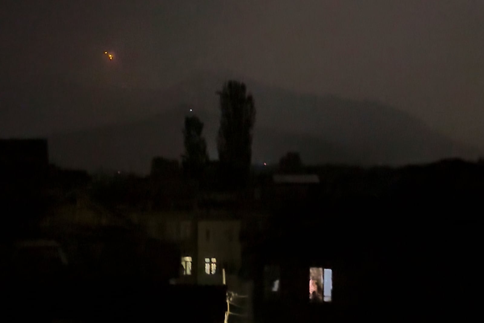 Red projectiles are seen on the horizon in Srinagar, in Indian controlled Kashmir, Saturday, May 10, 2025. (AP Photo/Mukhtar Khan)