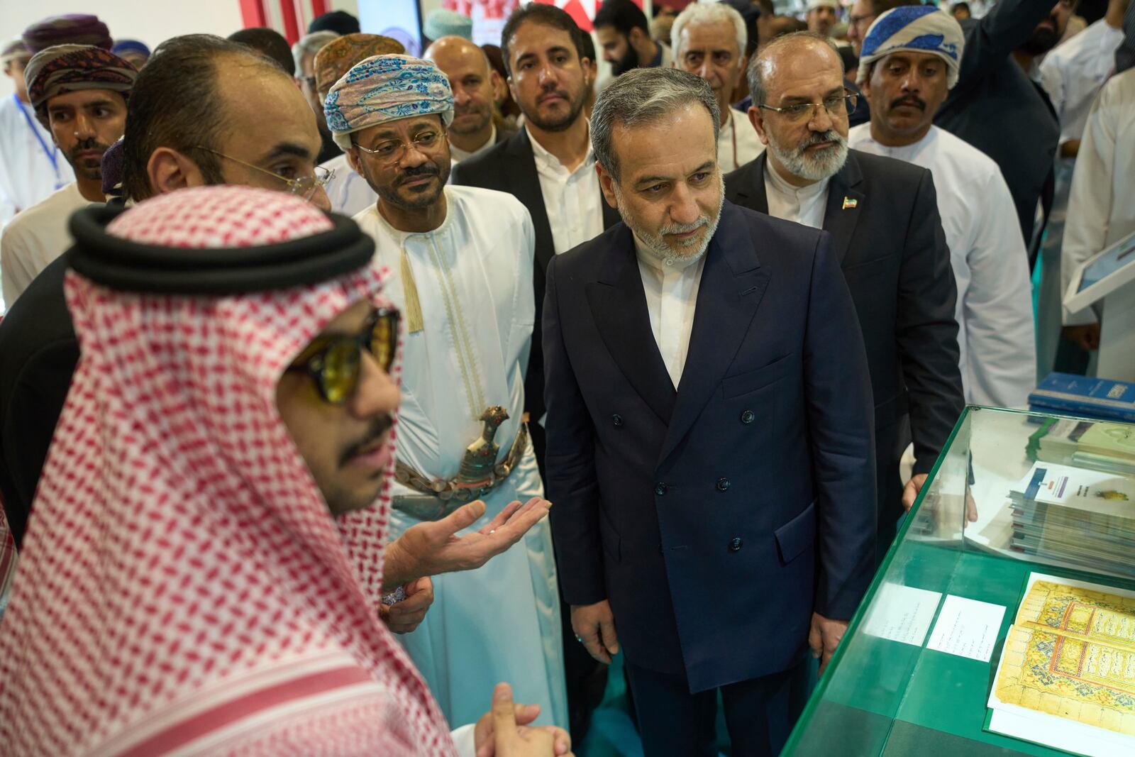 Iranian Foreign Minister Abbas Araghchi, center right, and Omani Foreign Minister Badr al-Busaidi, center left, walk through the Muscat International Book Fair in Oman, Friday, April 25, 2025. (AP Photo/Fatima Shbair)