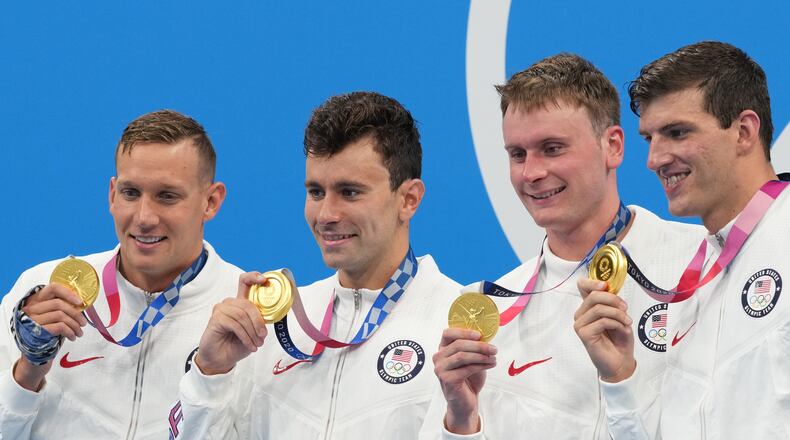 From left, Caeleb Dressel, Blake Pieroni, Bowen Becker and Zach Apple of the United States wear their gold medals during the medal ceremony for the men’s 4x100-meter freestyle relay, at the Tokyo Aquatics Centre during the delayed 2020 Olympics in Tokyo, July 26, 2021. (Doug Mills/The New York Times)