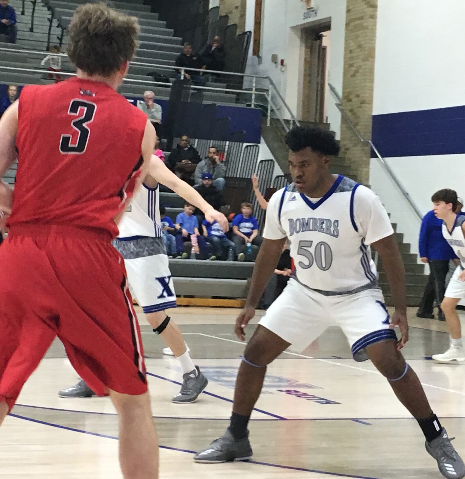 St. Xavier’s Bobby Jefferson (50) has his defensive game face on as Lakota West’s Spencer Farthing (3) handles the ball Tuesday night at Berning Gym in Springfield Township. RICK CASSANO/STAFF