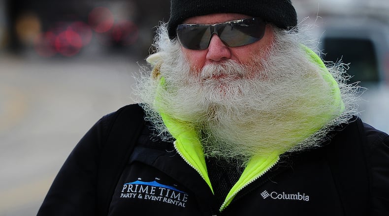 The beard of John K. Berger gets blowed around as he walks near downtown Dayton on a windy Thursday afternoon Feb. 9, 2023. MARSHALL GORBY\STAFF