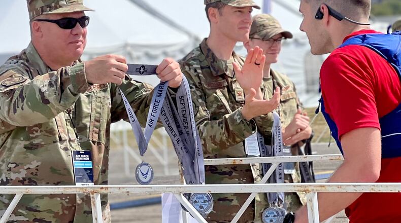 Participants in Saturday's 27th annual Air Force Marathon receive medals at the race's finish line on the grounds of the Air Force Museum. AIMEE HANCOCK/STAFF