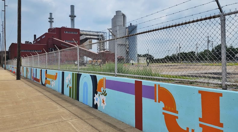 StreetSpark artists and community volunteers helped paint a 400 ft. mural called "Natural History" on the wall in front of Hamilton power plant during the ElecriCity event in Hamilton. NICK GRAHAM/STAFF