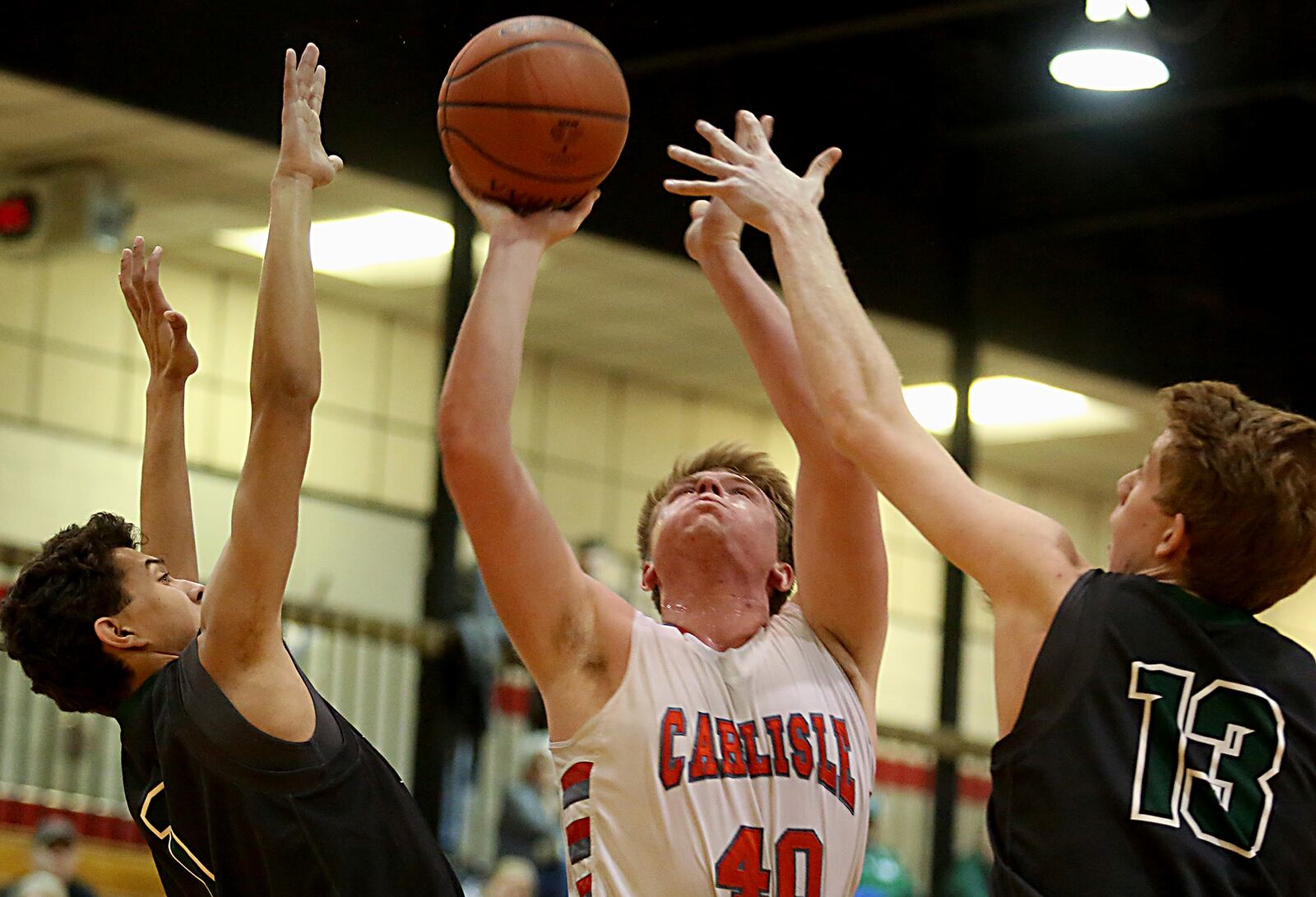 Carlisle forward Logan Baker puts up a shot between Badin’s Caleb Meyer (1) and Justin Pappas (13) during Saturday night’s game at The Pit in Carlisle. CONTRIBUTED PHOTO BY E.L. HUBBARD