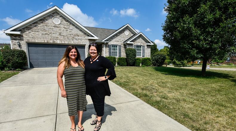 Katie Rowland, left, stands by Donna Deaton with RE/MAX Victory realtors in front of the house Rowland is selling in Monroe. Rowland, who is having a home built in Liberty Twp., sold her home on the first day it was listed. NICK GRAHAM/STAFF