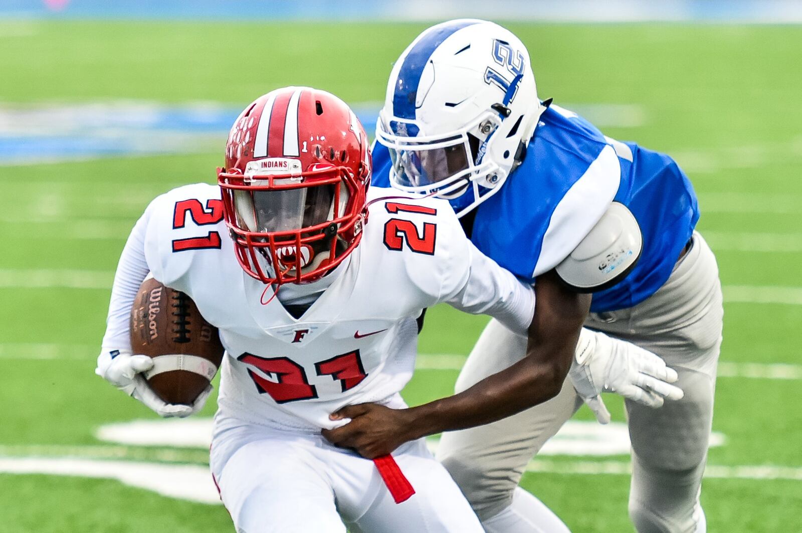 Fairfield’s Dashaun Simpkins carries the football as Hamilton’s James Turner makes the tackle from behind Friday night at Virgil Schwarm Stadium in Hamilton. NICK GRAHAM/STAFF