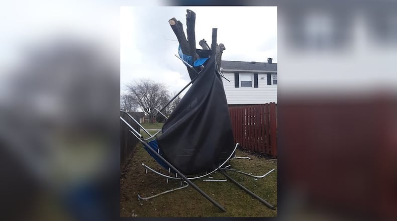 High winds picked up this trampoline and wrapped it around a tree at a home in Huber Heights Monday morning. Contributed photo