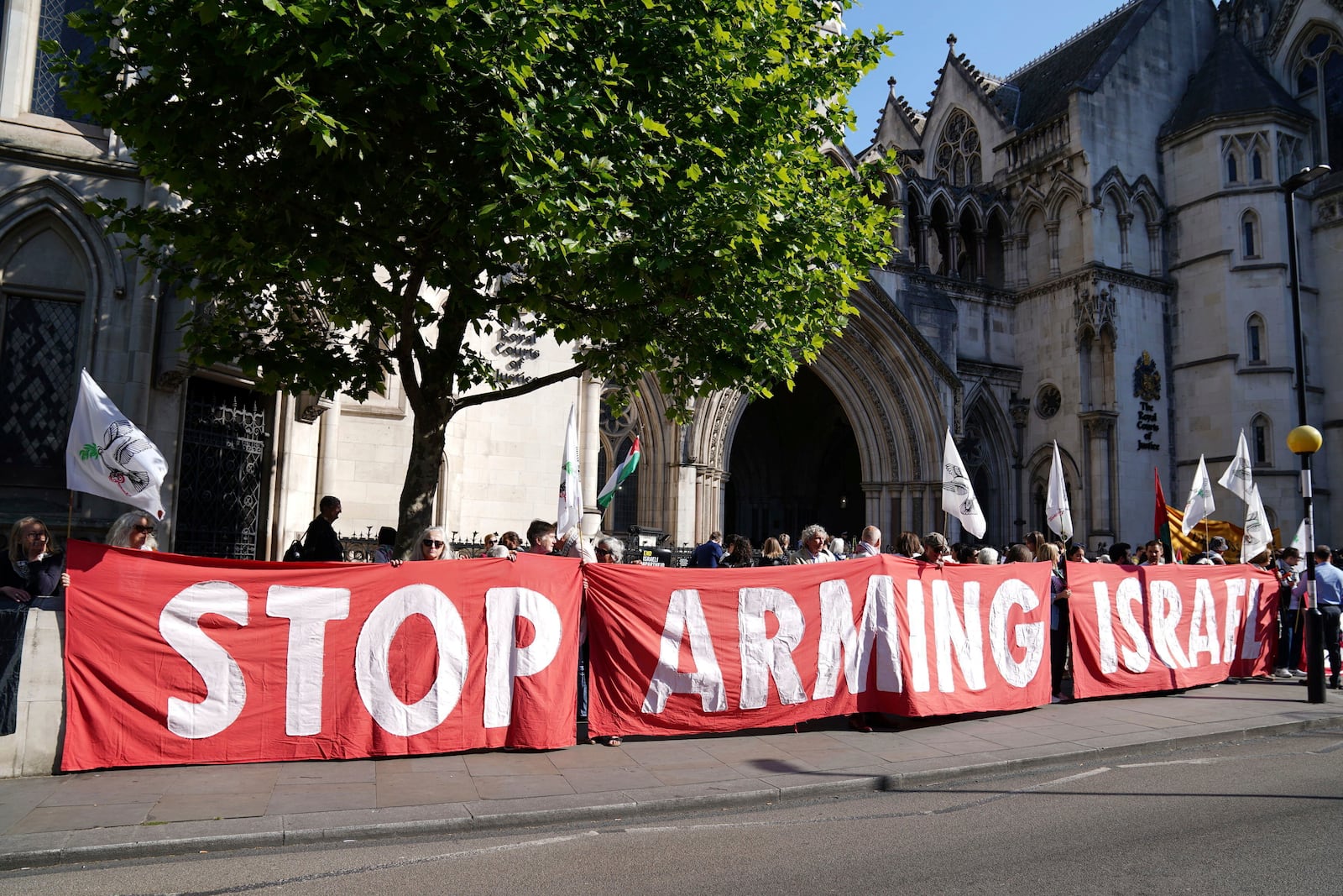 Demonstrators gather outside the Royal Courts of Justice in London, where Palestinian human rights organization Al-Haq is taking legal action against the Department for Business and Trade over several decisions, Tuesday May 13, 2025. (Ben Whitley/PA via AP)