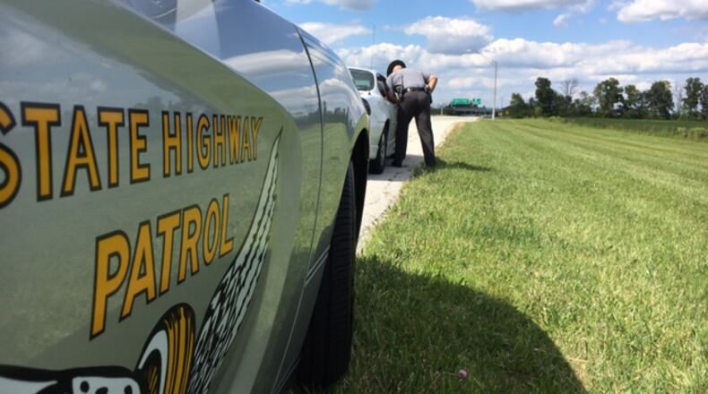 Ohio Highway Patrol Sgt. Frank Simmons speaks with a driver he pulled over on the access road to Dayton International Airport. Drivers near airports and on Friday afternoons are often distracted, law enforcement officers say. THOMAS GNAU/STAFF