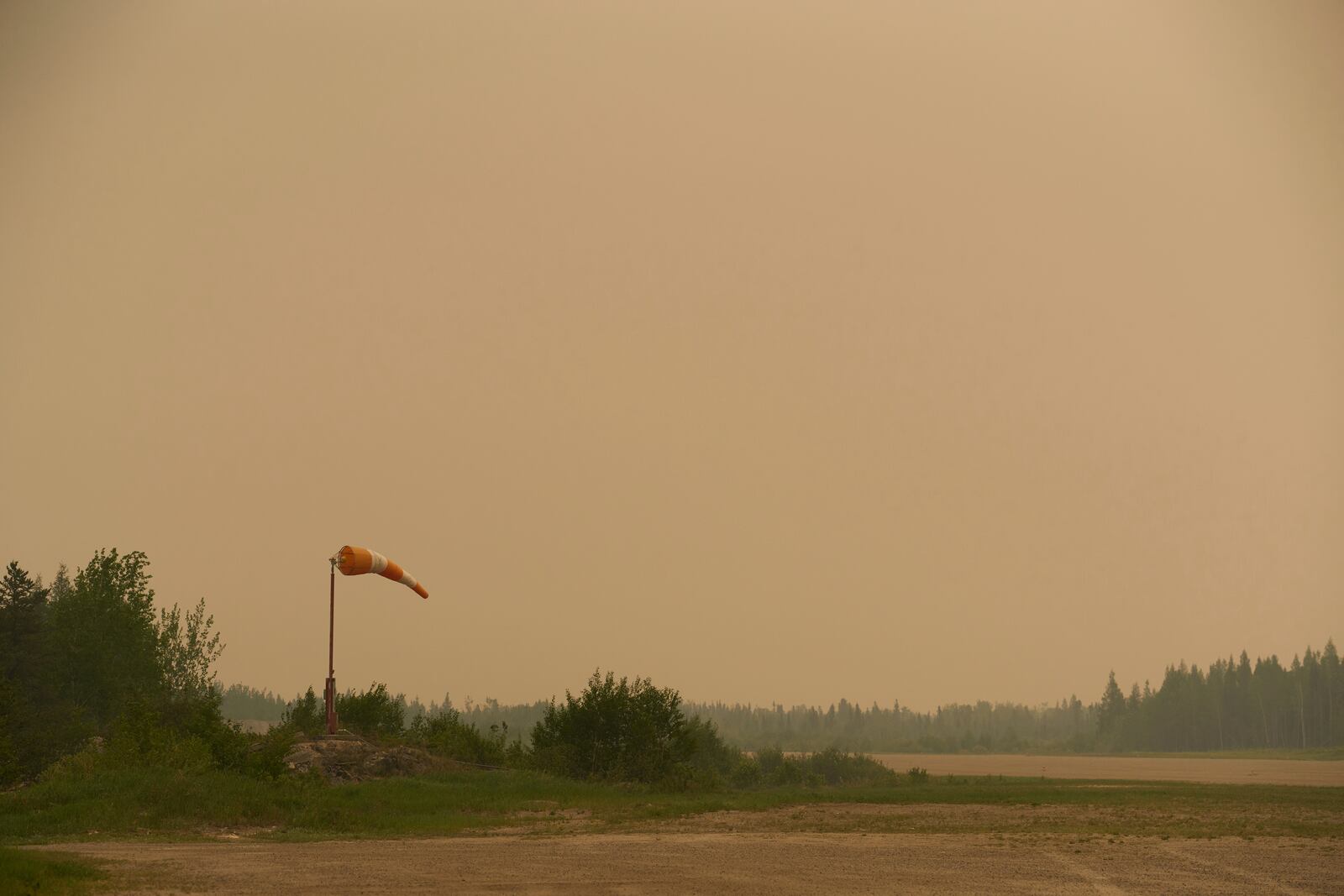 Smoke filled skies from out of control wildfires in Norway House, Manitoba Tuesday, June 3, 2025, at the Norway House Airport as crews continue to fight wildfires in northern Manitoba. (David Lipnowski/The Canadian Press via AP)