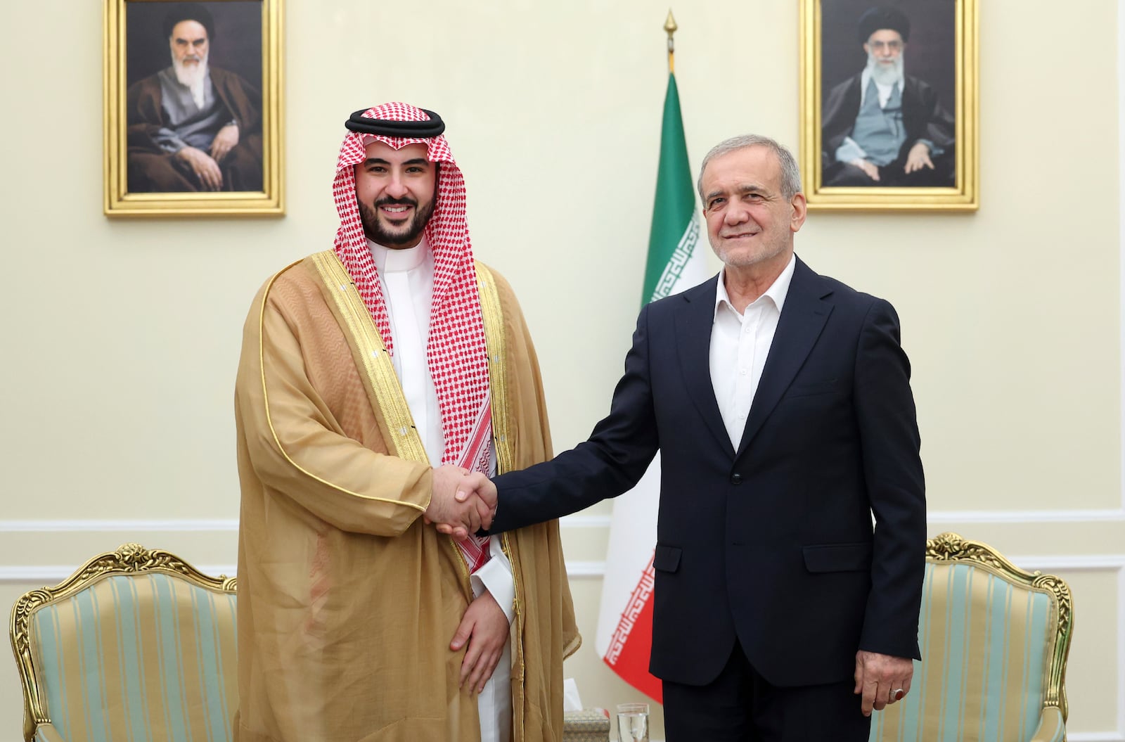 In this photo released by the Iranian Presidency Office, President Masoud Pezeshkian, right, shakes hands with Saudi Arabia's Defense Minister Prince Khalid bin Salman at the start of their meeting, in Tehran, Iran, Thursday, April 17, 2025. (Iranian Presidency Office via AP)