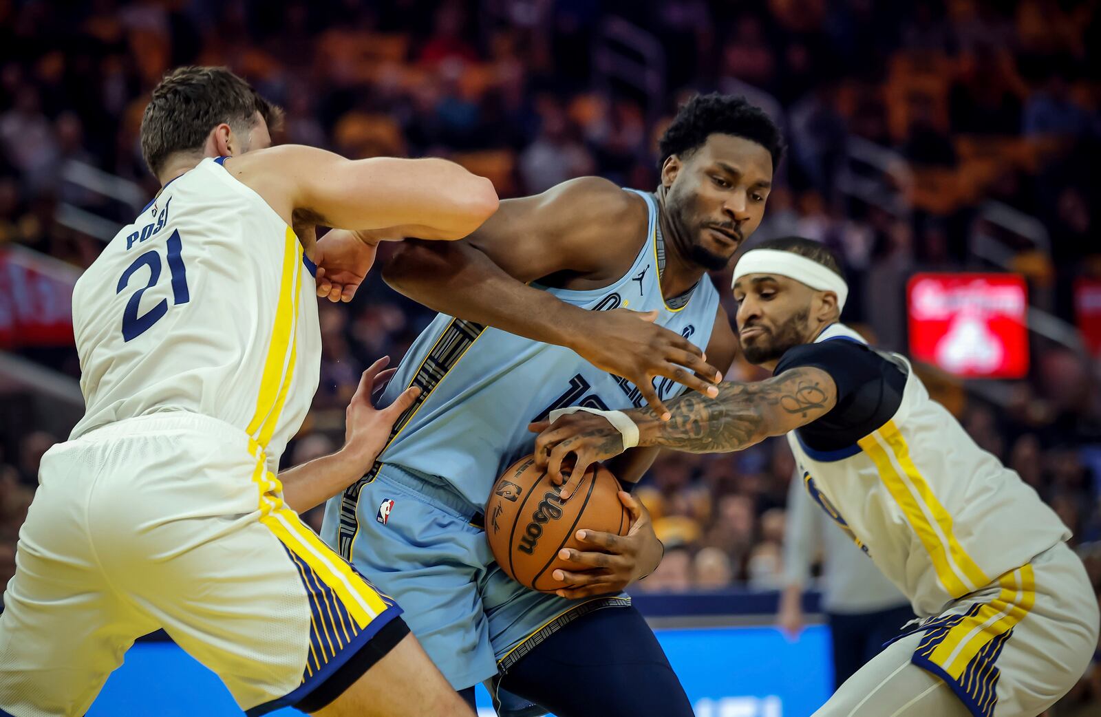 Golden State Warriors' Gary Payton II, right, forces a jump ball against Memphis Grizzlies' Jaren Jackson Jr., center, during the first half of an NBA play-in tournament basketball game in San Francisco, Tuesday, April 15, 2025. (Carlos Avila Gonzalez/San Francisco Chronicle via AP)