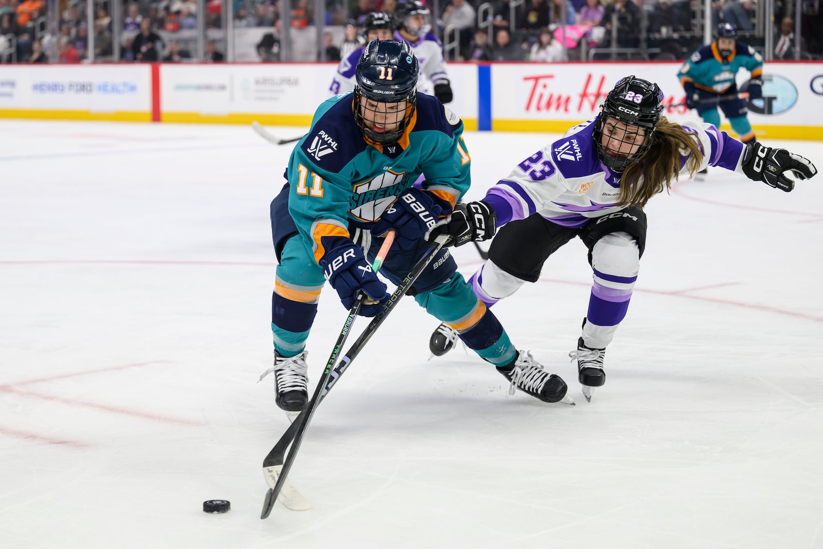 FILE - New York forward and Sault Ste. Marie, native Abby Roque, left, and Minnesota defenseman and Plymouth native Mellissa Channell-Watkins battle for the puck during the first period of a PWHL game between the New York Sirens and the Minnesota Frost, at Little Caesars Arena, in Detroit, Sunday, March 16, 2025. (David Guralnick/Detroit News via AP, File)