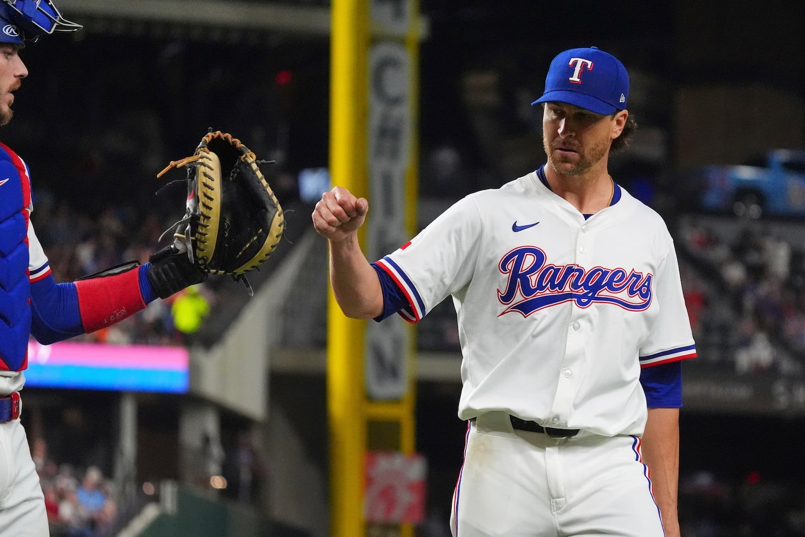 Texas Rangers starting pitcher Jacob deGrom, right, reaches out to teammate catcher Jonah Heim after the final out ending the seventh inning of a baseball game against the Houston Astros, Thursday, May 15, 2025, in Arlington, Texas. (AP Photo/LM Otero)