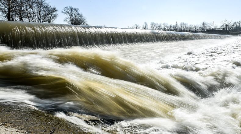 Water flows over the low level dam on the Great Miami River at Combs Park in Hamilton.