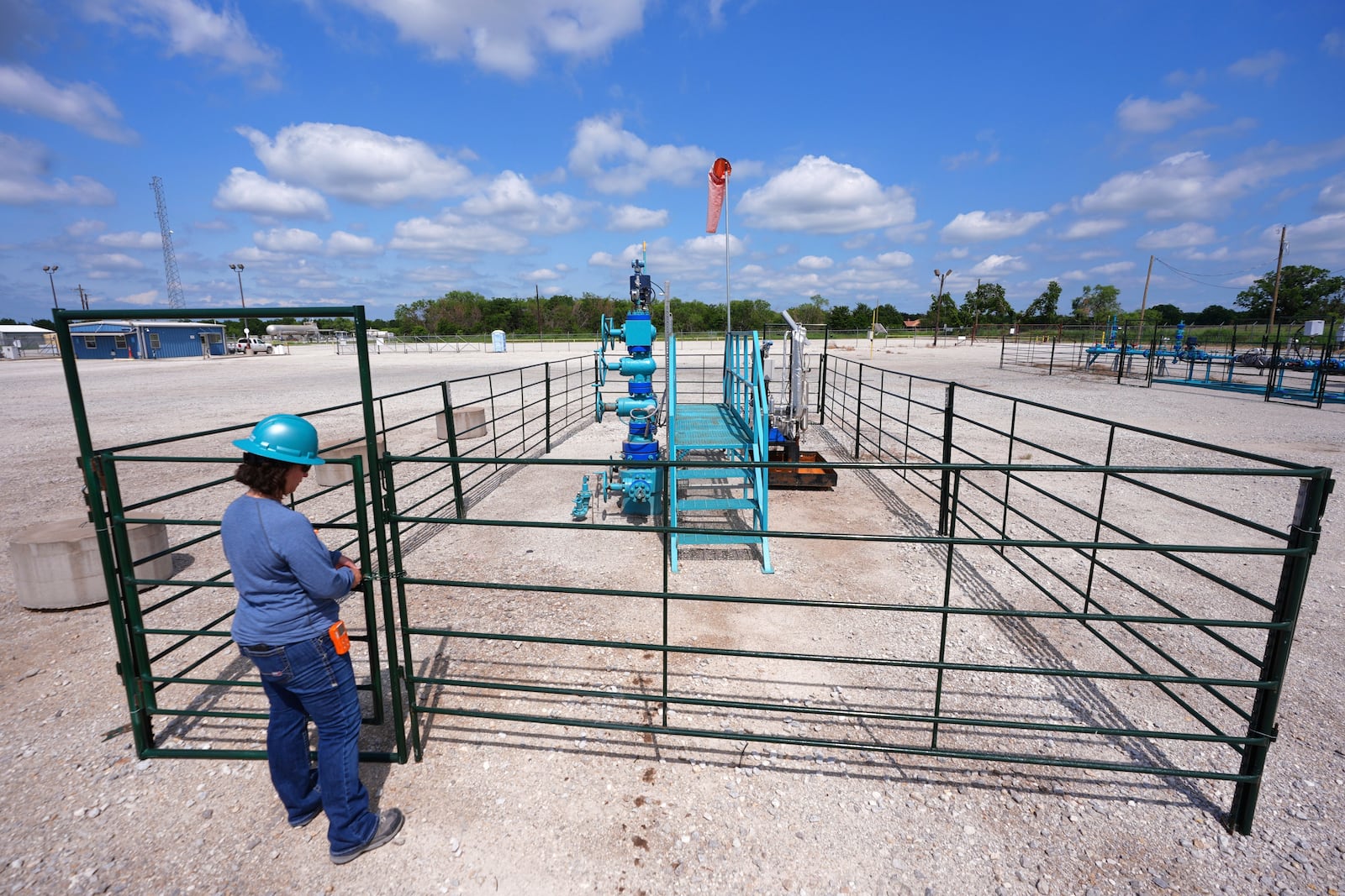 BKV Carbon Ventures senior facility engineer Laura Mamazza closes a gate on a carbon sequestration injection well pad site at a carbon capture and sequestration facility in Bridgeport, Texas, Thursday, May 29, 2025. (AP Photo/LM Otero)