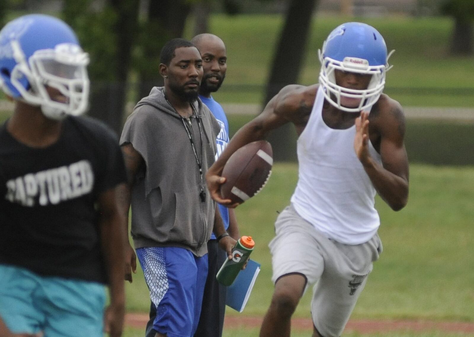 Dunbar football coach Darran Powell (middle) oversees practice last season. MARC PENDLETON / STAFF