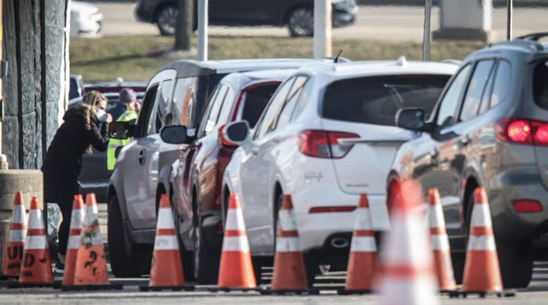 Vehicles line up at the University of Dayton Arena Wednesday Jan. 20, 2021 for a drive thru COVID-19 vaccine distribution. .