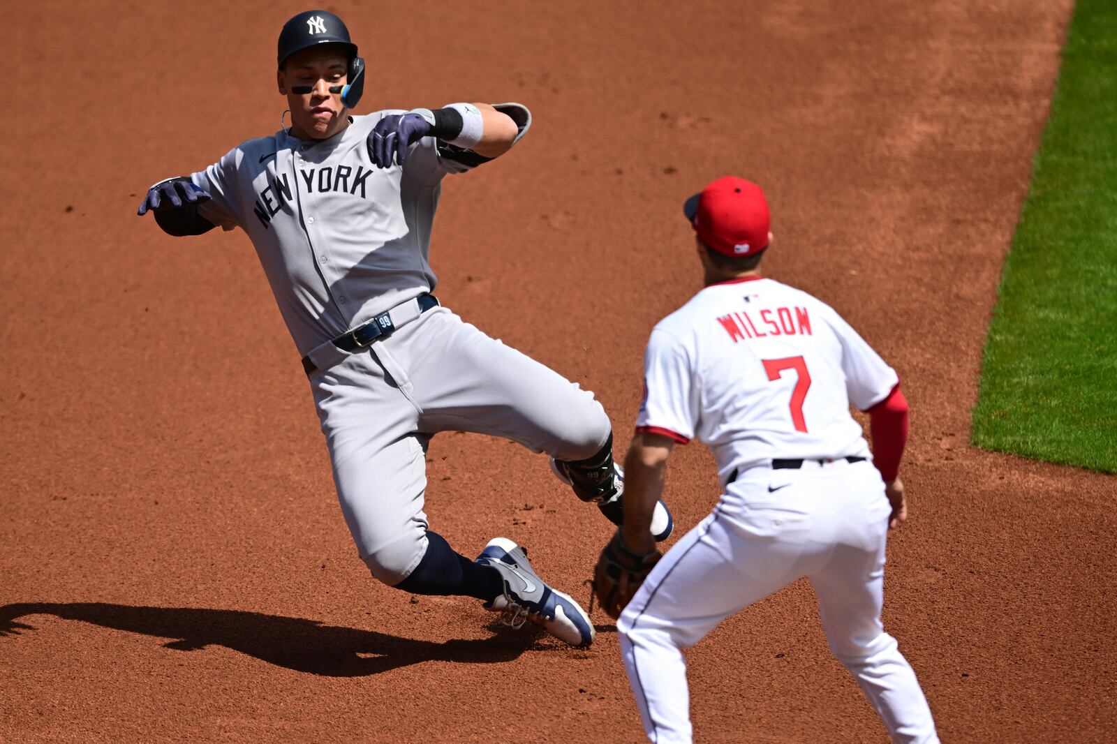 New York Yankees right fielder Aaron Judge slides into third base after hitting an RBI triple during the first inning of a baseball game against the Cleveland Guardians Wednesday, April 23, 2025, in Cleveland. (AP Photo/David Dermer)