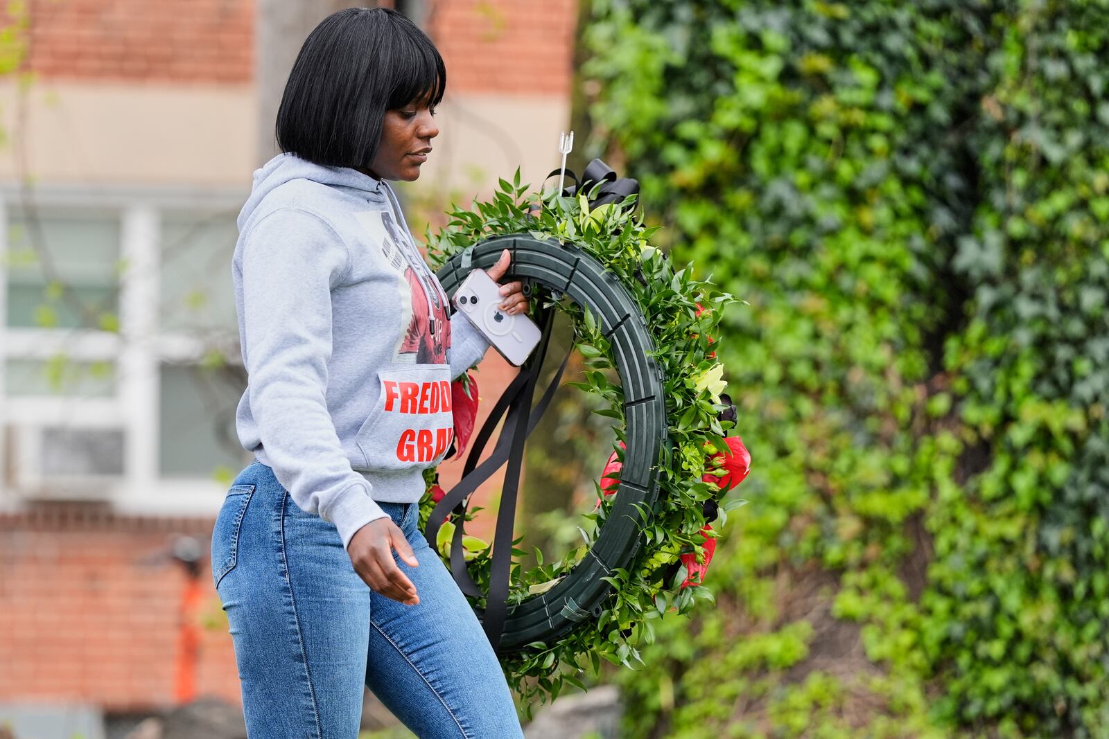 Fredricka Gray, twin sister of Freddie Gray, walks with a wreath to lay during a memorial event commemorating the ten-year anniversary of her brother's death, Saturday, April 19, 2025, in Baltimore. (AP Photo/Stephanie Scarbrough)