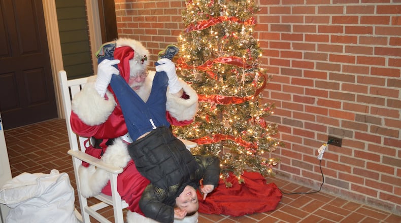 Scott Shriver, who is known as Santa Ray Scott, knows how to make a child’s visit with Santa a memorable one, even if it means being silly and giving him an upside-down view of the world. CONTRIBUTED/BOB RATTERMAN