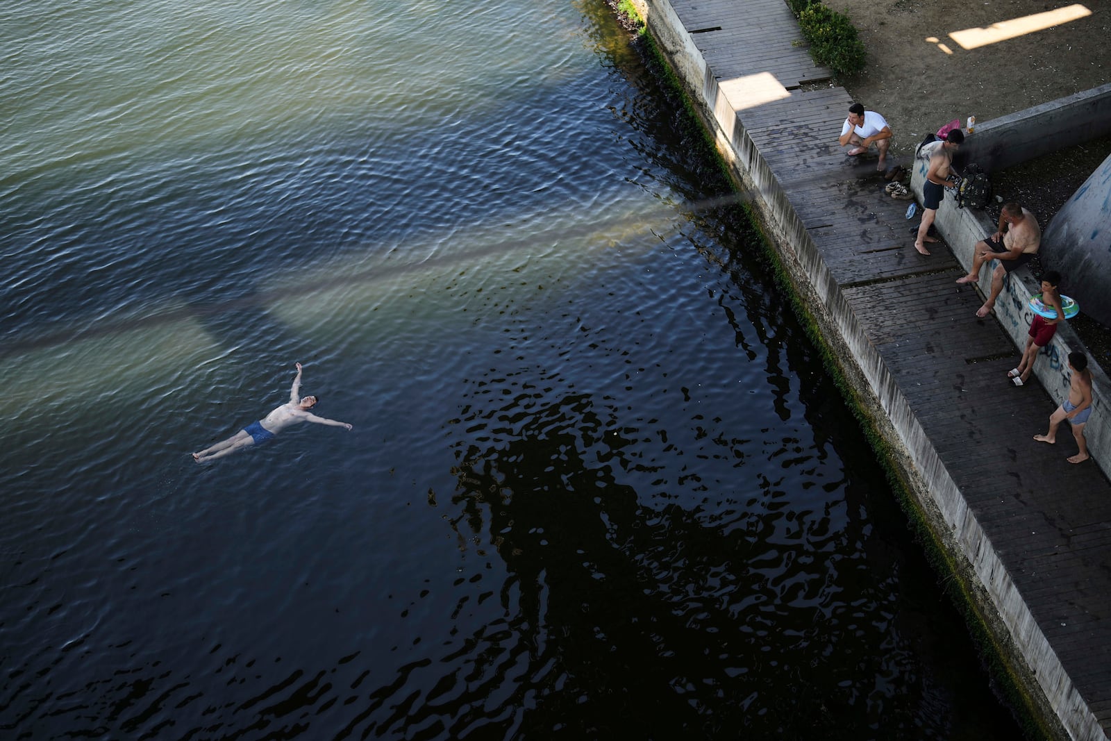 People cool off at the Bosphorus as they shelter against the sun under Halic bridge during a hot summer day, in Istanbul, Turkey, Friday, July 25, 2025. (AP Photo/Francisco Seco)