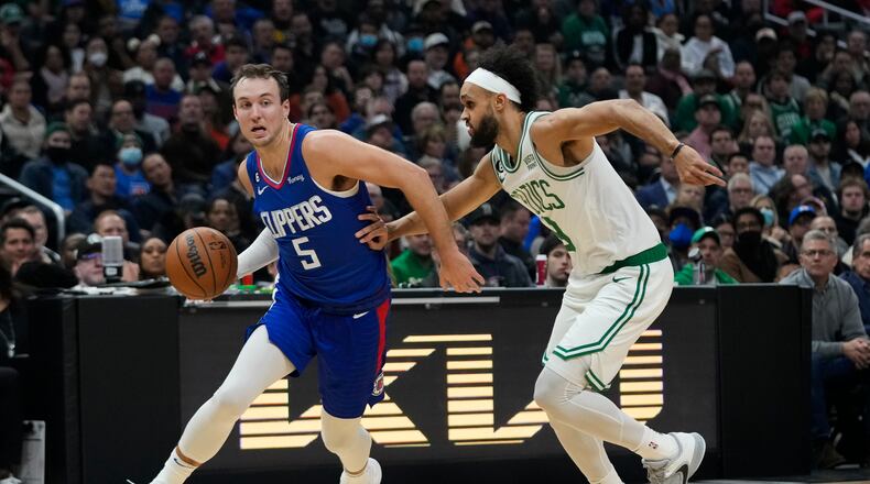 Los Angeles Clippers' Luke Kennard (5) drives past Boston Celtics' Derrick White during first half of an NBA basketball game Monday, Dec. 12, 2022, in Los Angeles. (AP Photo/Jae C. Hong)