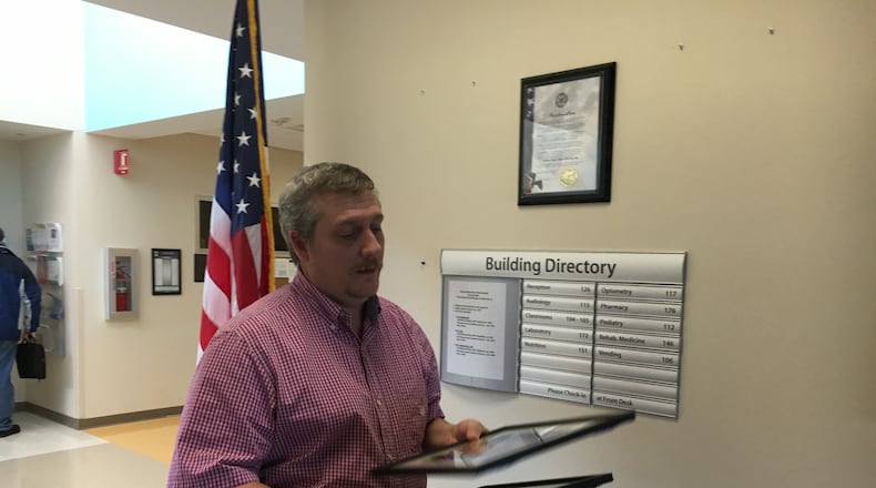 John Ward, office manager at the Middletown VA Clinic, removes photos of former President Barack Obama and former Secretary of Veterans Affairs Bob McDonald from the clinic’s wall today. RICK McCRABB/STAFF