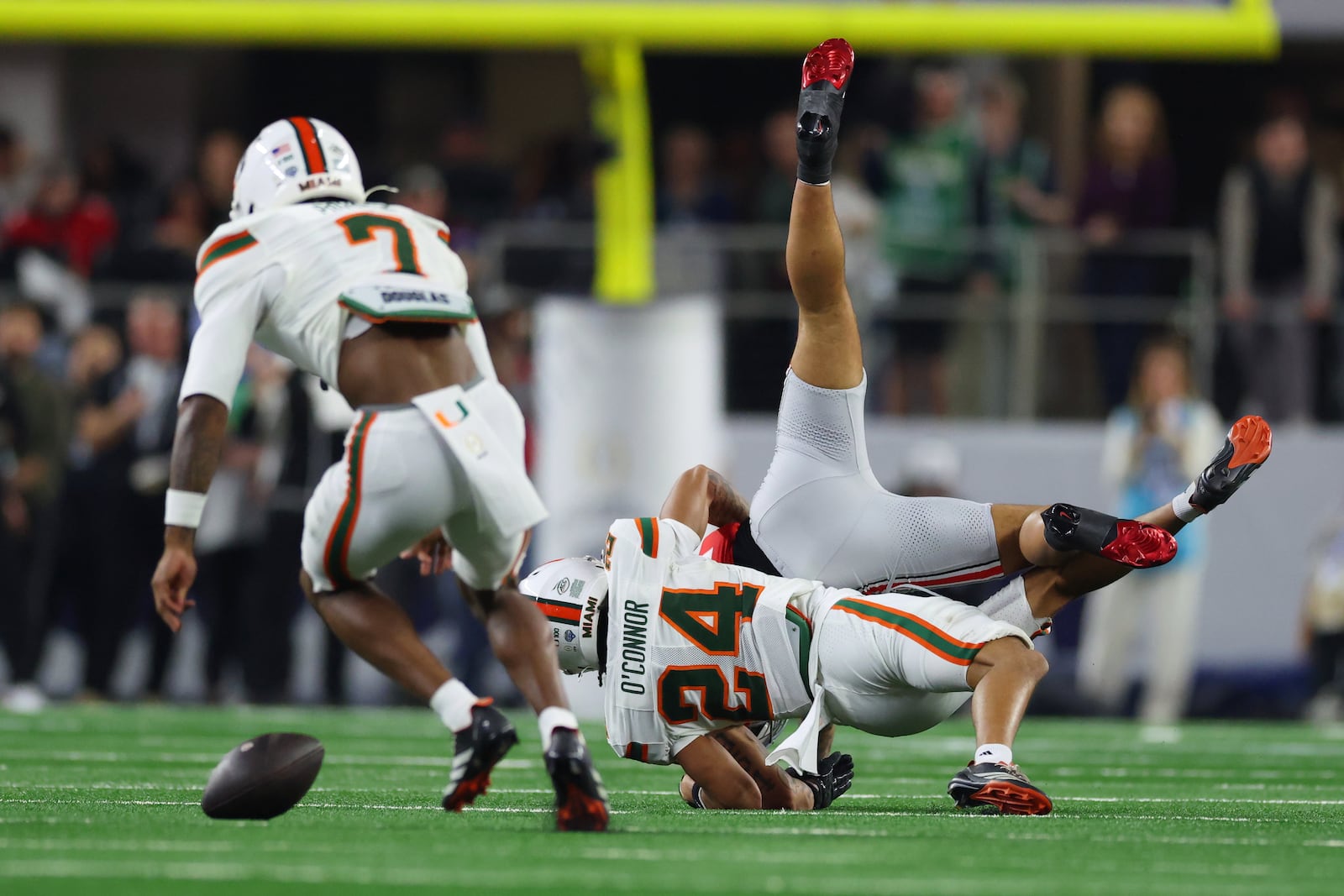 Miami defensive back Ethan O'Connor (24) drops Ohio State wide receiver Brandon Inniss after breaking up a pass during the first half of the Cotton Bowl College Football Playoff quarterfinal game Wednesday, Dec. 31, 2025, in Arlington, Texas. (AP Photo/Gareth Patterson)