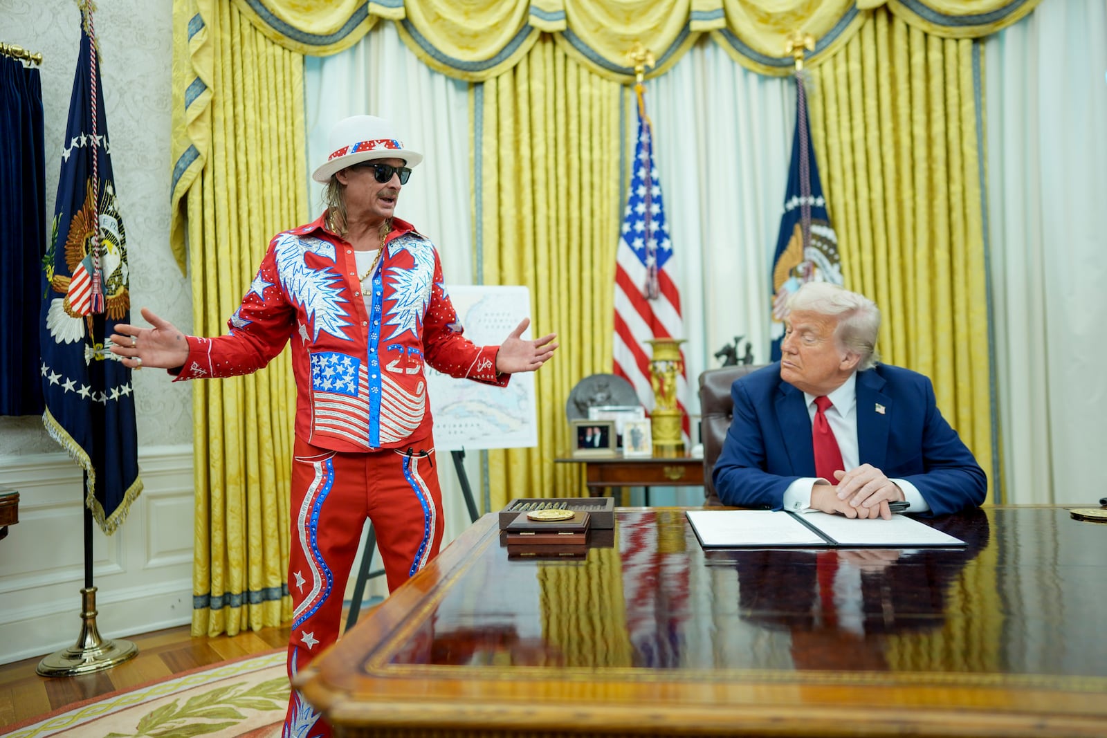 
                        President Donald Trump, alongside the singer Kid Rock, makes remarks as he signs executive orders in the Oval Office of the White House in Washington on Monday, March 31, 2025. (Doug Mills/The New York Times)
                      