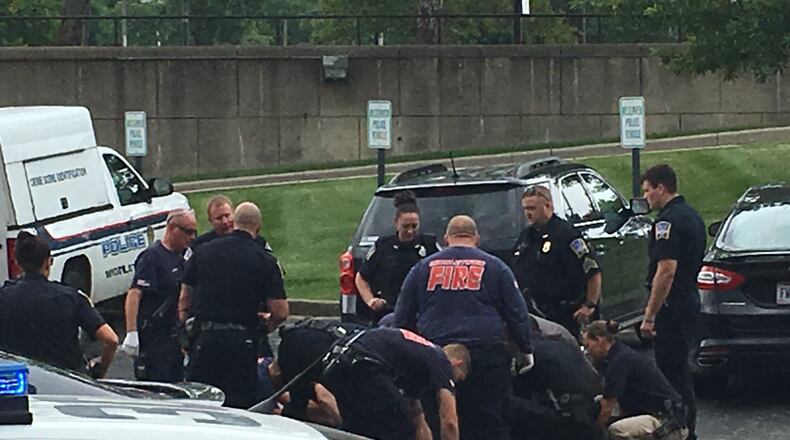 Middletown paramedics and police officers assist an officer tonight who fell in the parking lot. The officer was taken from the police station lot to Smith Park, where he was flown to Miami Valley Hospital. RICK McCRABB / STAFF