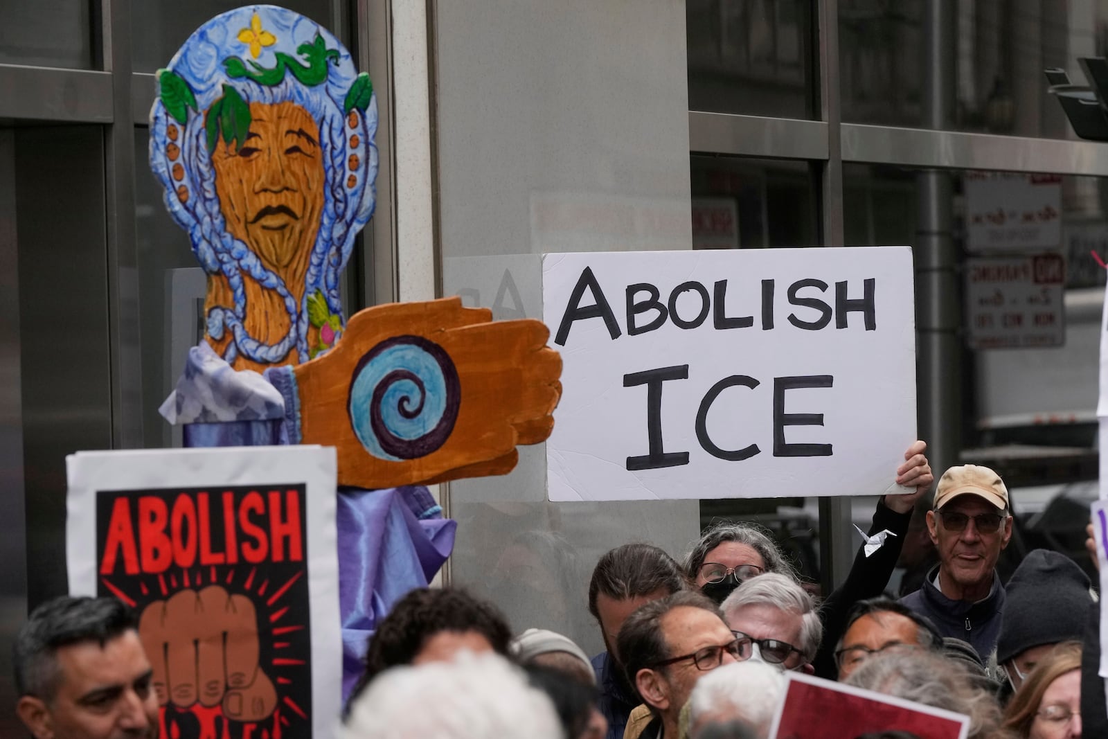 People hold up signs during a news conference and rally by immigrant justice organizations and advocates protesting ICE arrests in San Francisco, Wednesday, May 28, 2025. (AP Photo/Jeff Chiu)