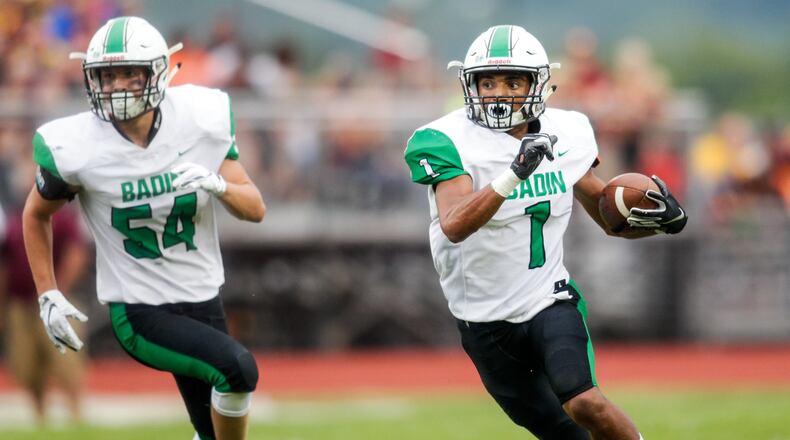 Badin’s Davon Starks carries the ball trailed by teammate Evan Schlensker during their season opener against Ross on Aug. 24 in Ross Township. Badin won 41-20. NICK GRAHAM/STAFF