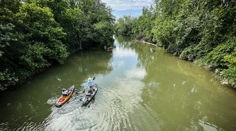 A couple of kayakers float down Twin Creek for overnight camping and fishing near West Alexander JIM NOELKER/STAFF.