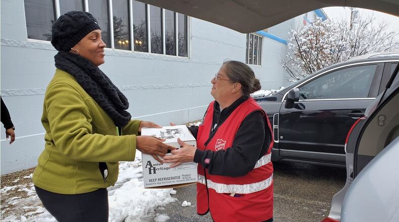 Buckeye Health Plan representative, Anisa Ballard handing their community partner a box of turkeys to support local meals this holiday season. CONTRIBUTED